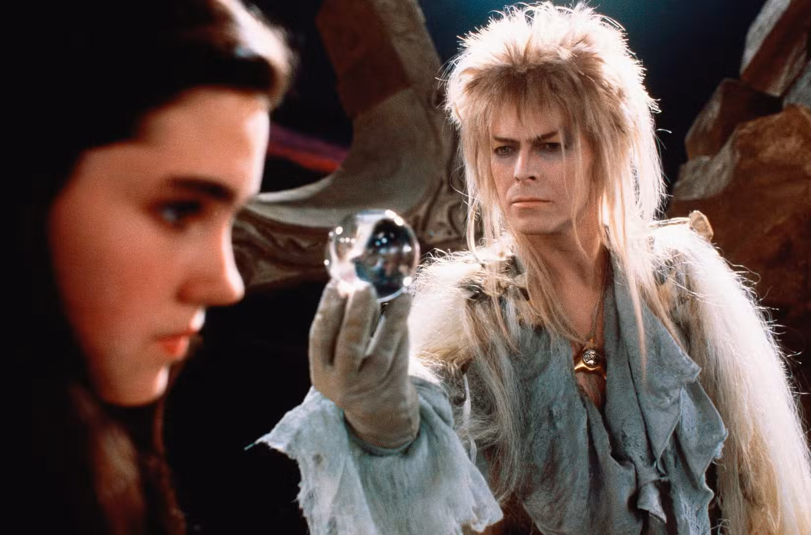 David Bowie como Jareth em Labirinto oferece uma bola de vidro para Jennifer Connelly como Sarah
