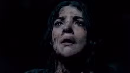 Uma jovem na produção do filme Until Dawn olha para cima, coberta de sujeira e sujeira, com uma expressão horrorizada no rosto.