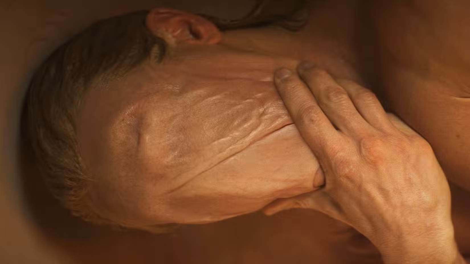 Um close de Clayface, com a mão no queixo e uma ponta contínua de pele da testa ao queixo, do primeiro teaser trailer do filme