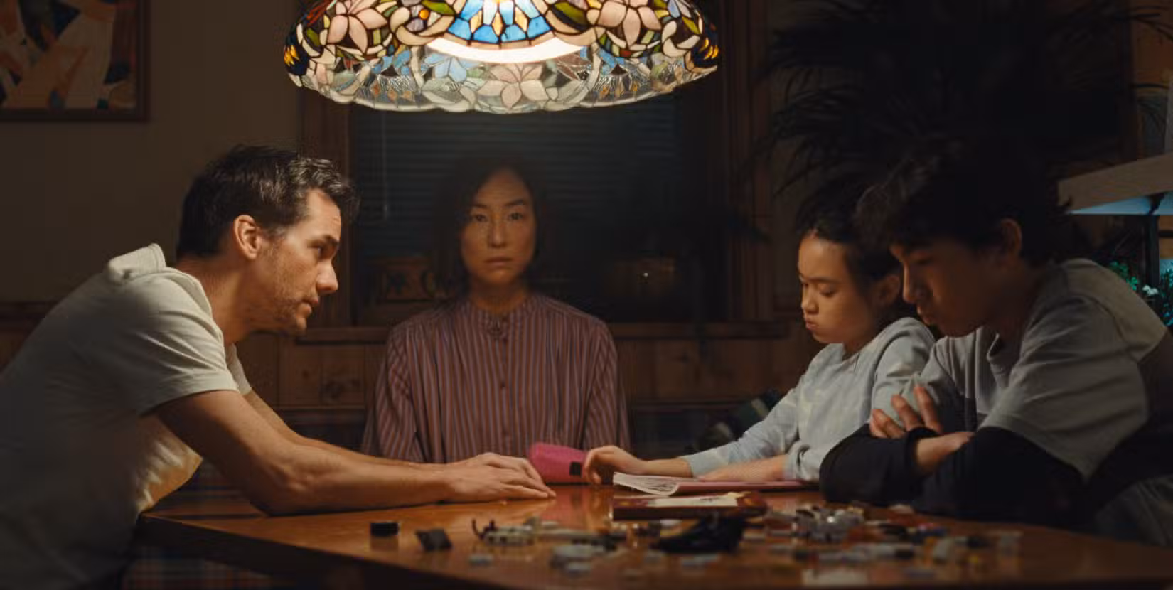 Uma captura de tela de The Last House, um filme da Netflix. Uma família de quatro pessoas está sentada à mesa.