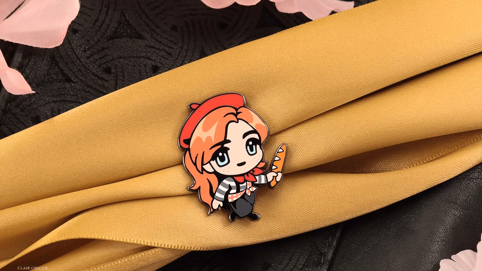 Um broche de Maelle da Expedição 33, onde ela segura uma baguete enquanto veste o traje francês alternativo do jogo. 
