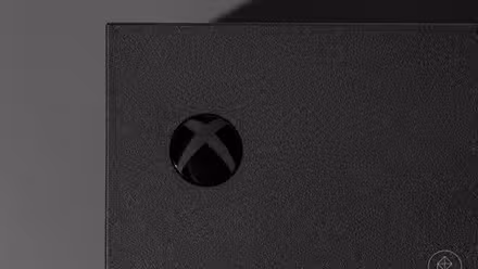 close do botão liga/desliga do Xbox em um console de videogame Xbox Series X fotografado em um fundo cinza escuro