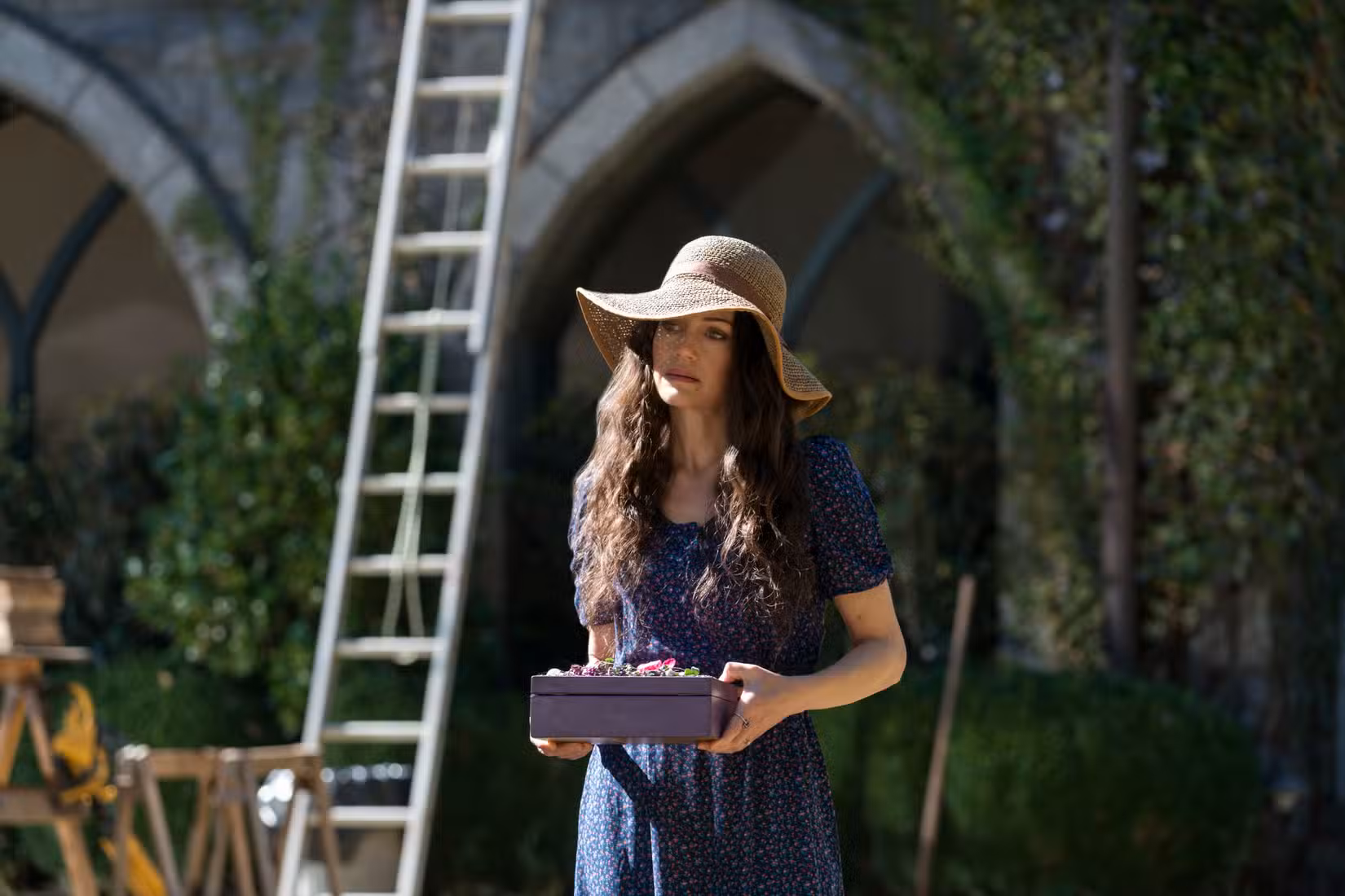 Olivia Crain segura uma caixa enquanto conversa com seus filhos em The Haunting of Hill House