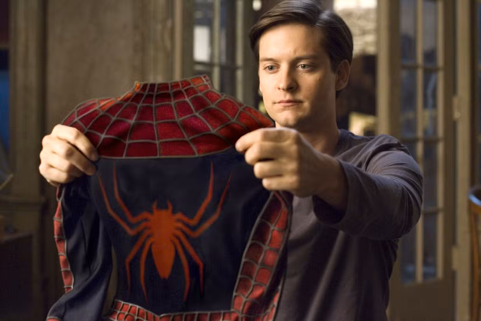 Peter Parker (Tobey Maguire) segura sua fantasia de Homem-Aranha em Homem-Aranha 3
