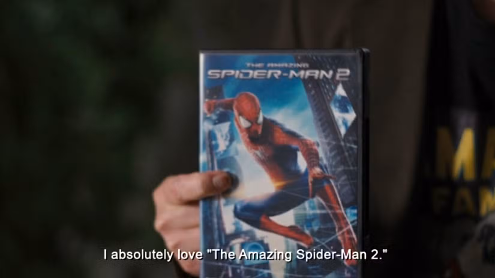 O criador de Naruto, Masashi Kishimoto, segura uma cópia em DVD de The Amazing Spider-Man 2 dizendo 