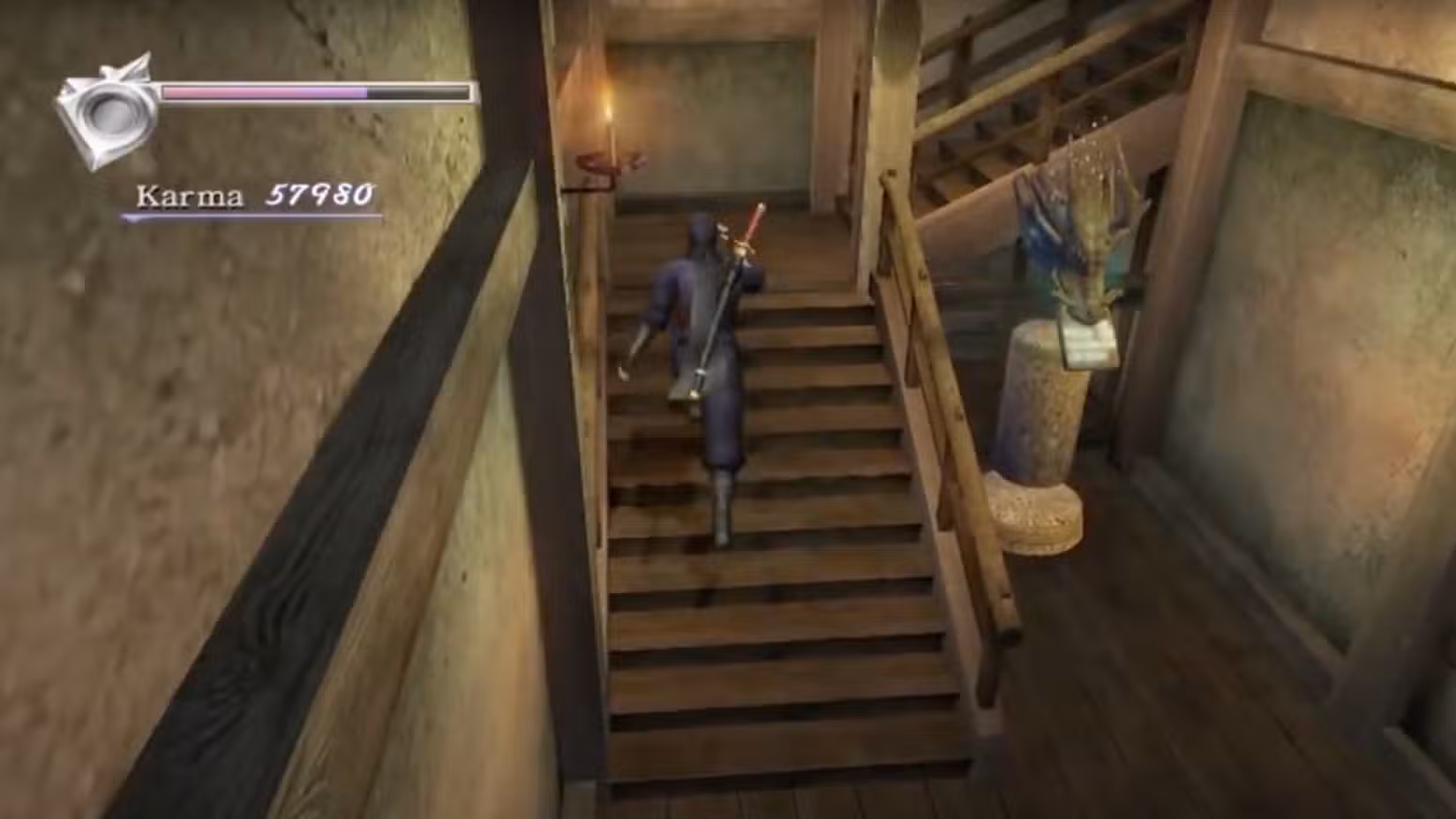 Uma captura de tela do jogo de Ninja Gaiden Black, mostrando Ryu subindo escadas internas