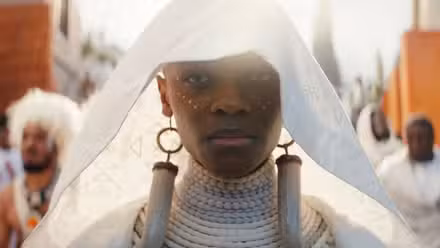 Letitia Wright como Shuri, parecendo sombria em seu traje funerário em Black Panther: Wakanda Forever da Marvel Studios.