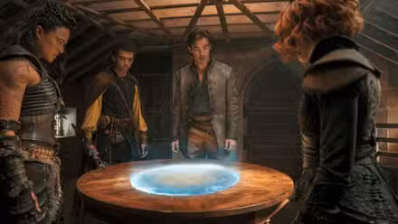 Um grupo de D&D sujo e maltratado (Michelle Rodriguez, Justice Smith, Chris Pine e Sophia Lillis) se reúne em torno de um mapa circular brilhante em uma cena de Dungeons & Dragons: Honor Among Thieves