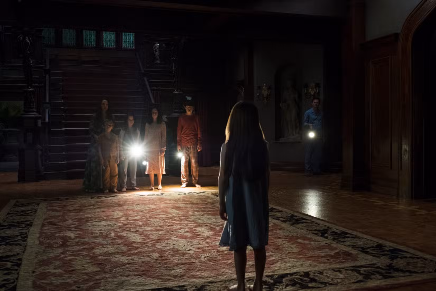 Uma jovem Nelly encara o resto de sua família em The Haunting of Hill House